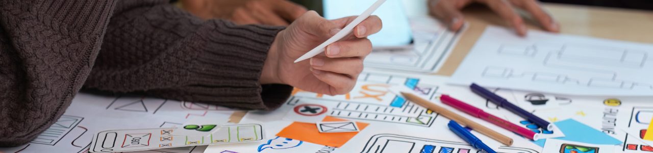 Close up ux developer and ui designer use augmented reality brainstorming about mobile app interface wireframe design on desk at modern office. creative digital development agency.